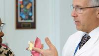 Doctor reviewing an ear diagram with a patient.